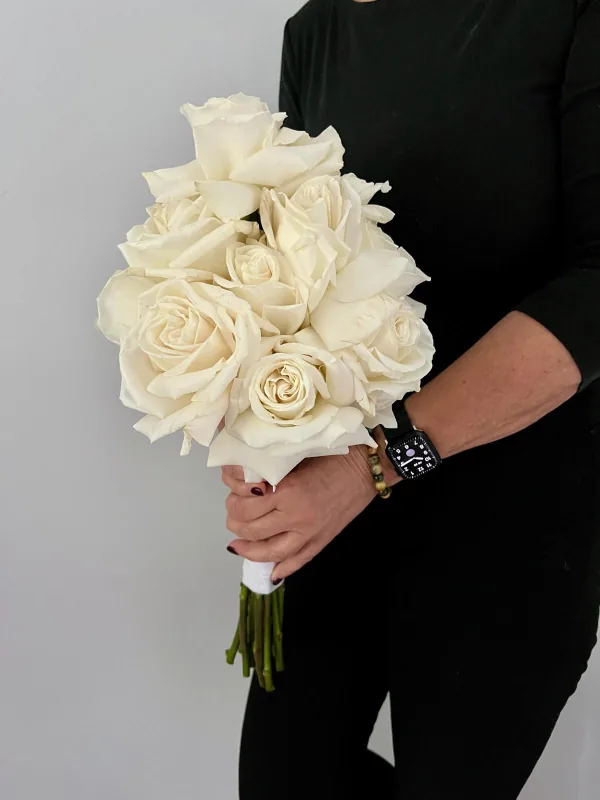 Kompakter klassischer Brautstrauß aus weißen Rosen mit umwickelten Stielen