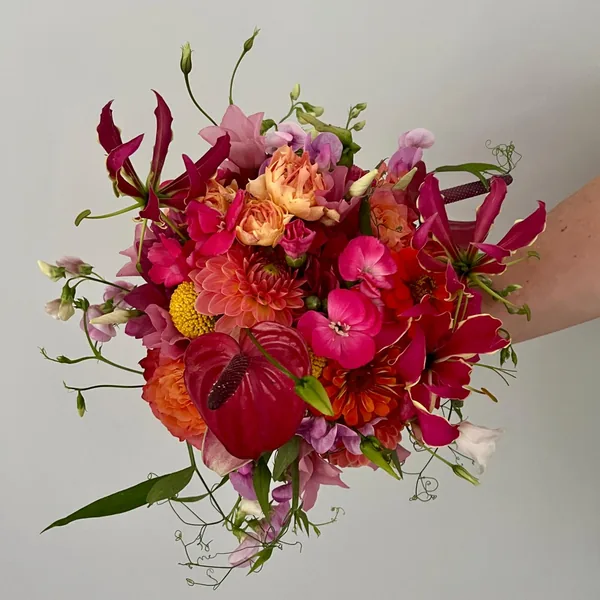 Leuchtender Strauß mit Dahlien, Anthurien und Gloriosa in Magenta und Koralle