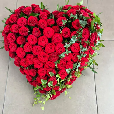 Herz aus roten Rosen mit einer Ranke aus Efeu