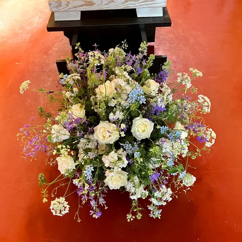 Sarggesteck aus weißen Rosen, blauen Blüten und violettem Rittersporn