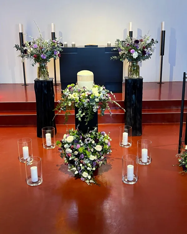 Urnenschmuck in Weiß, Grün und Violett mit Kranz und Kerzen